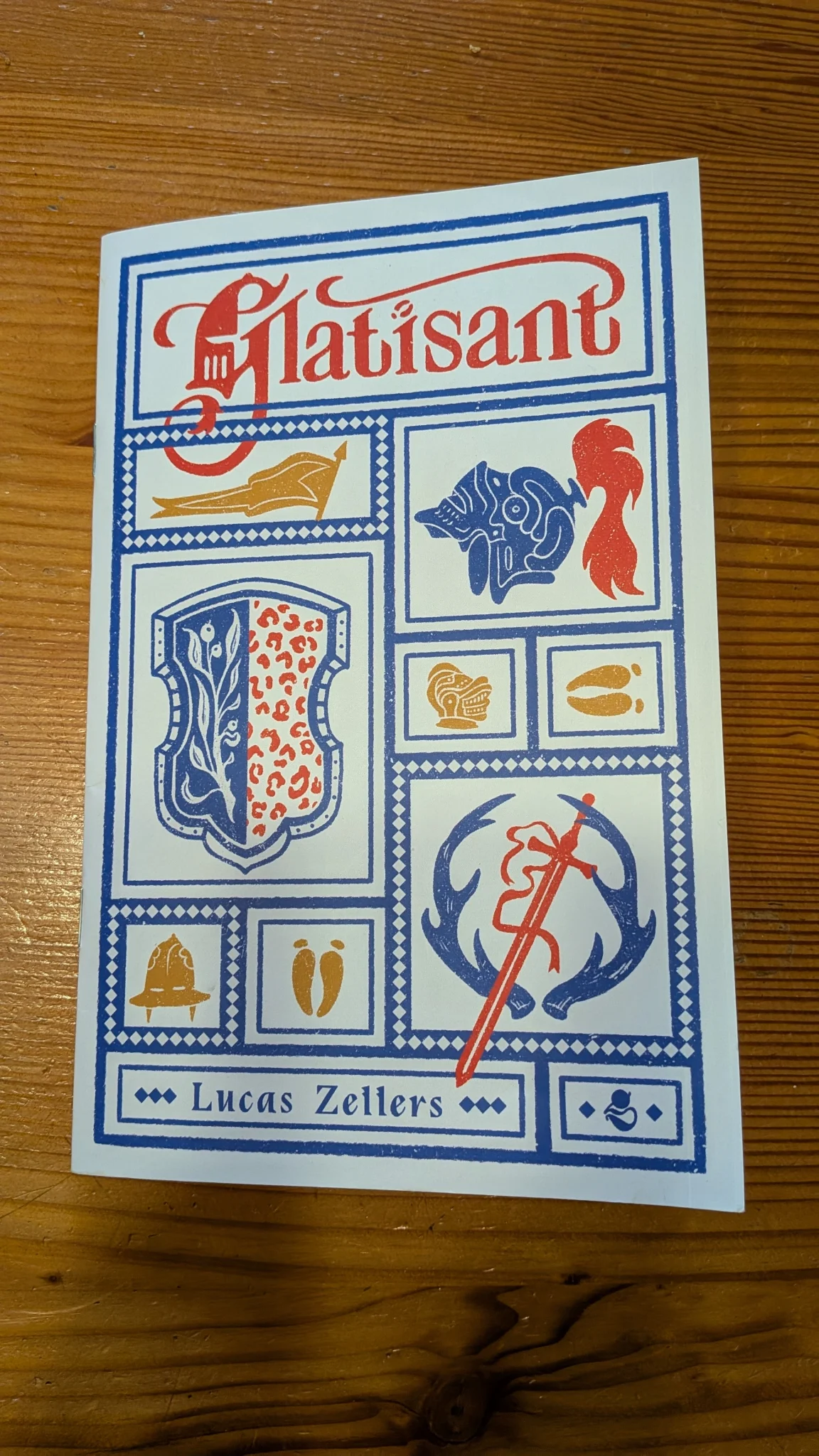 The cover of Glatisant. The name is at the top in Medieval script and red. The rest of the cover is full of blue, gold, and red symbols to imply the Knightly and Beastly nature of the participants.