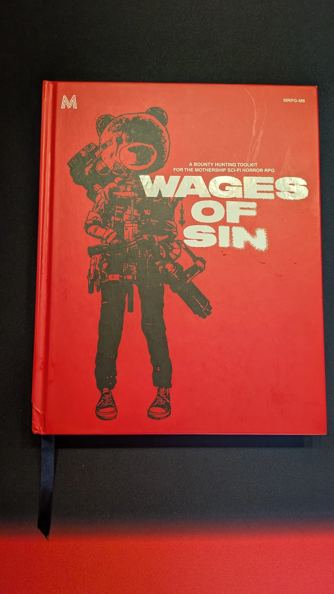 Wages of Sin cover is red with a black image of a bounty hunter with a teddy bear head on.